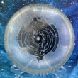 Load image into Gallery viewer, Top-down view of a brand-new light purple sparkle DGA Aftershock midrange disc golf disc in SP Line plastic with a black foil Gravity Black Hole custom stamp.
