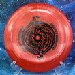 Load image into Gallery viewer, Top-down view of a red sparkle DGA Torrent distance driver disc golf disc in SP Line plastic featuring a black foil Black Hole special edition stamp.
