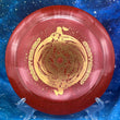 Load image into Gallery viewer, Top-down view of a red sparkle DGA Torrent distance driver disc golf disc in SP Line plastic featuring a gold foil Black Hole special edition stamp.
