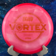 Load image into Gallery viewer, Top-down view of a pink DGA Catrina Allen Vortex fairway driver disc golf disc in Atmos plastic featuring an orange foil Catrina Allen signature series stamp.
