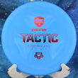 Load image into Gallery viewer, Top-down view of a blue swirled Discmania Tactic approach disc golf disc in Hard Exo plastic featuring an orange foil stock Evolution Tactic stamp.
