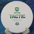 Load image into Gallery viewer, Top-down view of a white Discmania Tactic approach disc golf disc in Hard Exo plastic featuring a green foil stock Evolution Tactic stamp.
