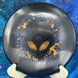 Load image into Gallery viewer, Top-down view of a black Infinite Discs Cohort putt and approach disc golf disc in I-Blend plastic with a black, orange, and blue three-foil Neon Alien Head stamp.
