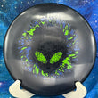 Load image into Gallery viewer, Top-down view of a black Infinite Discs Cohort putt and approach disc golf disc in I-Blend plastic with a black, orange, and blue three-foil Neon Alien Head stamp.
