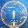 Load image into Gallery viewer, Top-down view of an Innova Fox Ohn Scoggins Commemorative Party Time midrange disc golf disc in purple and white Proto Glow Champion Halo plastic with a blue holographic foil stamp scaled at 180g.
