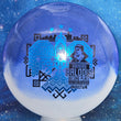 Load image into Gallery viewer, Top-down view of an Innova Teebird Rainers Balodis Commemorative fairway driver in blue and white Duo Star plastic with black and blue holo foil stamp scaled at 174g.
