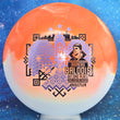 Load image into Gallery viewer, Top-down view of an Innova Teebird Rainers Balodis Commemorative fairway driver in orange and white Duo Star plastic with black and lavender holo foil stamp scaled at 174g.
