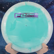 Load image into Gallery viewer, Top-down view of a white and teal Innova Tern distance driver disc golf disc in Halo Star plastic featuring a purple foil Factory Second F2 stamp.
