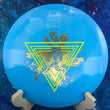 Load image into Gallery viewer, Top-down view of a blue Innova XCaliber distance driver disc golf disc in Star plastic featuring a neon yellow and light blue dual-foil Neon Astro special edition stamp.
