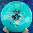Load image into Gallery viewer, Top-down view of a teal Innova XCaliber distance driver disc golf disc in Star plastic featuring a white and silver dual-foil Neon Astro special edition stamp.
