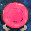 Load image into Gallery viewer, Top-down view of a pink MVP Nitro distance driver disc golf disc in Neutron plastic featuring a black GYRO overmold rim and black foil stock Nitro stamp.
