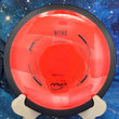 Load image into Gallery viewer, Top-down view of a red MVP Nitro distance driver disc golf disc in Neutron plastic featuring a black GYRO overmold rim and black foil stock Nitro stamp.
