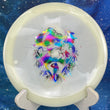 Load image into Gallery viewer, Top-down view of a glow Mint Discs Phoenix fairway driver disc golf disc in Nocturnal Glow plastic featuring a jellybean foil Unearthed special edition stamp.
