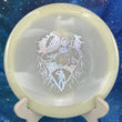 Load image into Gallery viewer, Top-down view of a glow Mint Discs Phoenix fairway driver disc golf disc in Nocturnal Glow plastic featuring a silver foil Unearthed special edition stamp.
