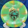 Load image into Gallery viewer, Top-down view of a lime and orange swirl Mint Discs Phoenix fairway driver disc golf disc in Apex Swirl plastic featuring a foil Unearthed special edition stamp.

