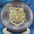 Load image into Gallery viewer, Top-down view of a pre-owned black glimmer Discraft Buzzz 2023 College Disc Golf National Championship edition midrange disc golf disc in ESP plastic scaled at 177g in brand new 10 out of 10 uninked condition.
