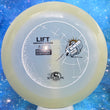 Load image into Gallery viewer, Top-down view of a pre-owned Streamline Discs Lift understable fairway driver disc golf disc in Glow Total Eclipse plastic scaled at 174g in 9.5 out of 10 uninked condition.
