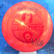 Load image into Gallery viewer, Top-down view of a pre-owned red on red Team Judge Dynamic Discs Judge putter disc golf disc in Fuzion plastic signed by Paige Shue and Zach Melton scaled at 175g in 10 out of 10 uninked condition.
