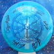 Load image into Gallery viewer, Top-down view of a pre-owned blue McBeth Tattar Wysocki and Conrad signed Dynamic Discs Justice midrange disc golf disc in Lucid Chameleon plastic scaled at 173g in 10 out of 10 uninked condition.
