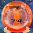 Load image into Gallery viewer, Top-down view of a translucent neon orange Streamline Trace distance driver disc golf disc in Proton plastic featuring a black and silver foil stock Trace stamp.
