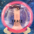 Load image into Gallery viewer, Top-down view of a translucent neon pink Streamline Trace distance driver disc golf disc in Proton plastic featuring a black and silver foil stock Trace stamp.
