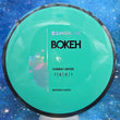 Load image into Gallery viewer, New Axiom Bokeh Midrange Driver in Neutron Plastic - Simon Line Special Edition with Black-Blue Swirl Rim and Teal Core.
