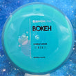 Load image into Gallery viewer, New Axiom Bokeh Midrange Driver in Neutron Plastic - Simon Line Special Edition with Blue Swirl Rim and Teal-Blue Core.
