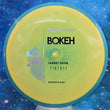 Load image into Gallery viewer, New Axiom Bokeh Midrange Driver in Neutron Plastic - Simon Line Special Edition with Blue Swirl Rim and Yellow Core.
