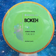Load image into Gallery viewer, New Axiom Bokeh Midrange Driver in Neutron Plastic - Simon Line Special Edition with Red-Yellow Swirl Rim and Green Core.
