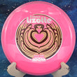 Load image into Gallery viewer, Top view of a Neon Pink Axiom Bokeh Simon Lizotte Team Series fairway driver in Neutron plastic with a Pink Swirl GYRO rim, featuring a Gold, Brown, and Silver Holo tri-foil "Bokeh Latte" stamp, 175g, 10/10 condition.
