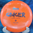 Load image into Gallery viewer, Top view of an Orange pre-owned Clash Discs Ginger overstable hybrid driver in First Run Steady plastic on a display stand, rated 8/10 condition.
