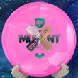Load image into Gallery viewer, Front view of a pink Discmania Mutant in Neo plastic, featuring the black Evolution Mutant stamp. This overstable disc golf midrange is shown on a display stand against a blue space-themed background.
