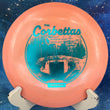 Load image into Gallery viewer, Top view of a Peach pre-owned Prodigy D6 understable distance driver in 400 plastic, featuring a blue and white event stamp, rated 9/10 condition and uninked.
